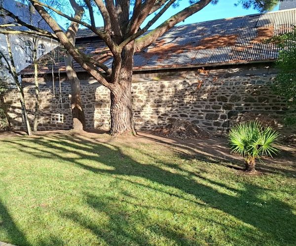 Bâtiment ancien en pierre rénové dans un environnement paysager